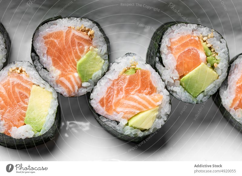 Leckere Futomaki-Norwegerollen mit Lachs Japanisch Sushi futomaki Kulisse Avocado Meeresfrüchte Fisch traditionell Kultur Speise Lebensmittel Reis Mahlzeit