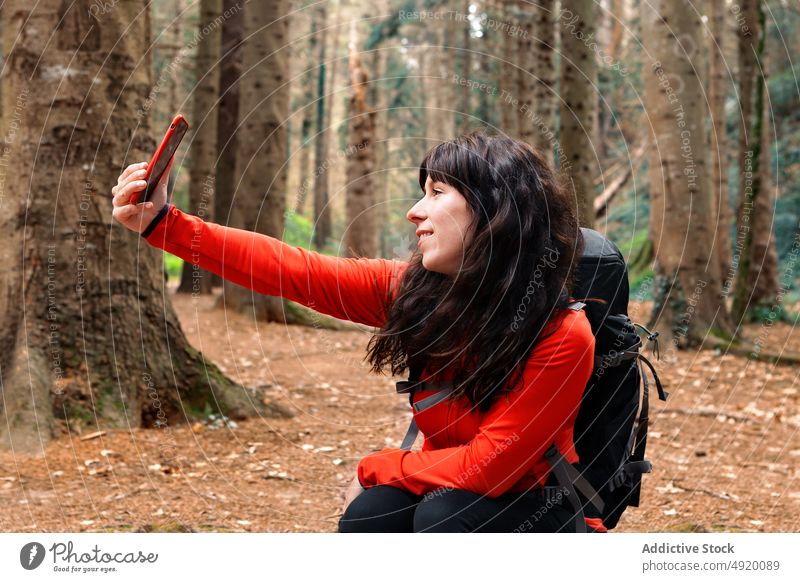 Weiblicher Wanderer macht Selfie im Wald Frau Lächeln Pause ruhen Wochenende reisen Smartphone Wälder Glück Rucksack Selbstportrait froh Reisender Baum Natur