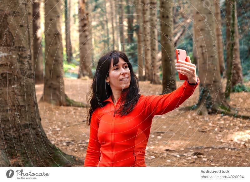 Weiblicher Wanderer macht Selfie im Wald Frau Lächeln Pause ruhen Wochenende reisen Smartphone Wälder Glück Selbstportrait froh Reisender Baum Natur Mobile