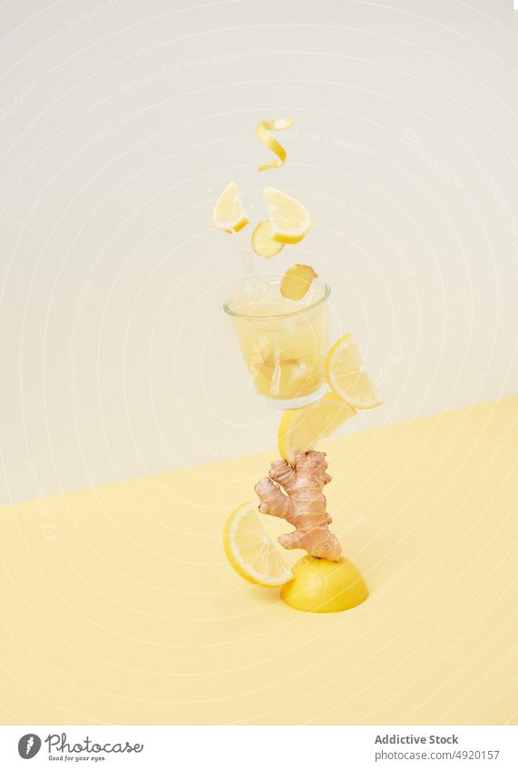 Zitronen, die mit Ingwer ins Glas fallen Erfrischung Getränk trinken Zitrusfrüchte Frucht Vitamin gesundes Getränk geschmackvoll Cocktail Bestandteil Scheibe