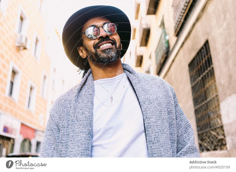 Stilvoller hispanischer Mann auf einer Straße in der Stadt Streetstyle urban tagsüber Outfit ruhen Vorschein männlich ethnisch Erwachsener modern trendy