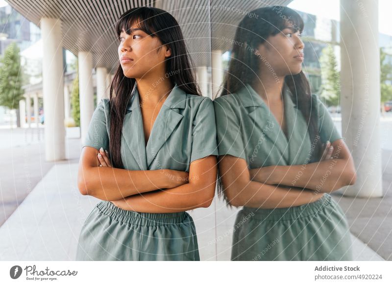 Asiatische Frau lehnt an einer Glaswand Straße fettarm ruhen Wochenende urban Stil Vorschein Reflexion & Spiegelung jung asiatisch ethnisch die Arme verschränkt