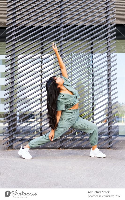 Asiatische Frau tanzt auf der Straße Tanzen urban Ausfallschritt Arm angehoben Wand Gebäude modern ausführen jung ethnisch asiatisch lange Haare Stil Tänzer
