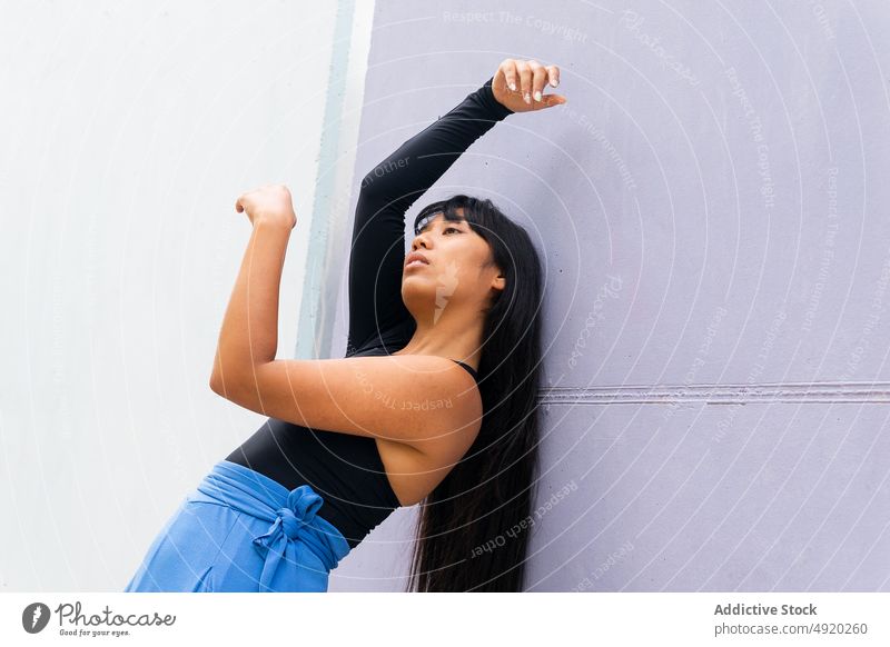 Asiatische Tänzerin beugt sich zurück Frau Tanzen Backend Straße Wand Anmut Gebäude ausführen Arme hochgezogen jung ethnisch asiatisch Energie Stil Talent