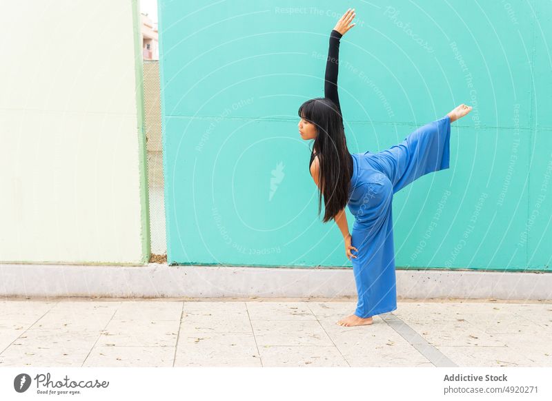 Asiatische Frau tanzt auf dem Bürgersteig Tanzen Straße Straßenbelag Anmut Wand Arm angehoben Ausfallschritt urban jung asiatisch ethnisch Energie Talent Barfuß