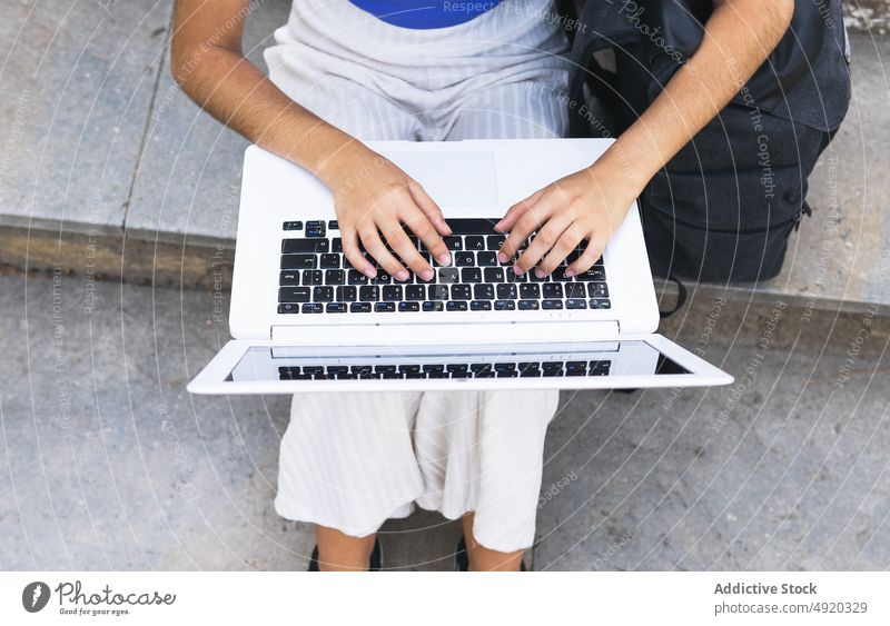 Anonyme Frau mit Laptop auf der Treppe Schüler Treppenhaus Straße Browsen online Großstadt Tippen Hausaufgabe Netbook benutzend Internet Aufgabe lernen Fokus