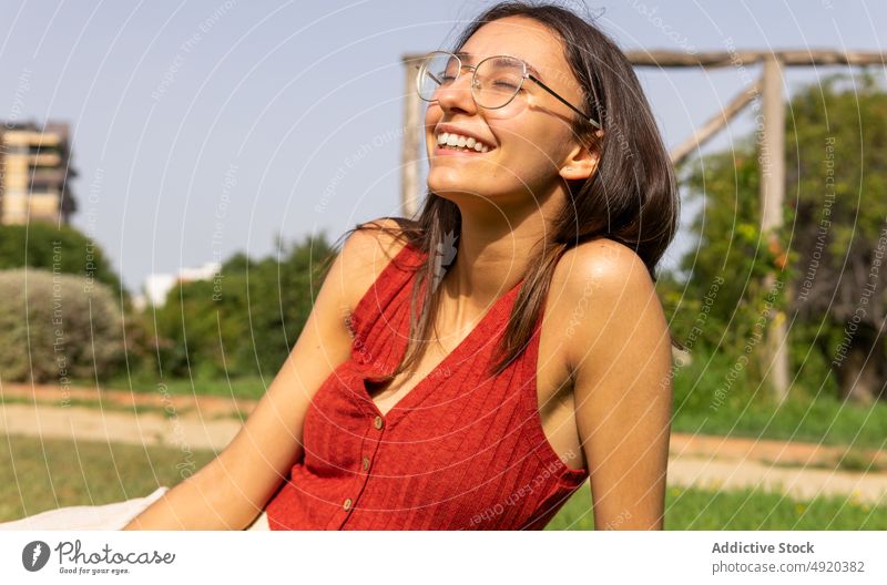 Glückliche Frau auf dem Rasen liegend Park ruhen genießen sorgenfrei Zeitvertreib Kälte feminin Sommer Lächeln positiv Großstadt heiter Baum Brille jung lässig