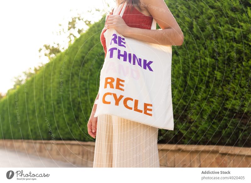 Anonyme Frau mit Stoffbeutel auf der Straße Tasche umdenken recyceln Aufschrift umweltfreundlich keine Verschwendung Textil wiederverwerten sparen