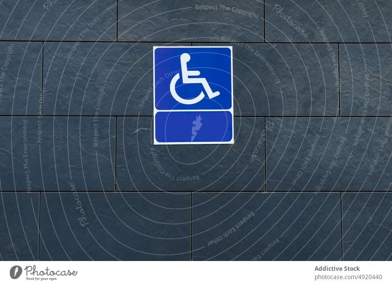 Erreichbarkeitszeichen auf grauer Wand Zeichen Zugang blanko deaktivieren Ikon Gebäude Straße Handicap Rollstuhl modern leer Geometrie Hinweisschild Symbol