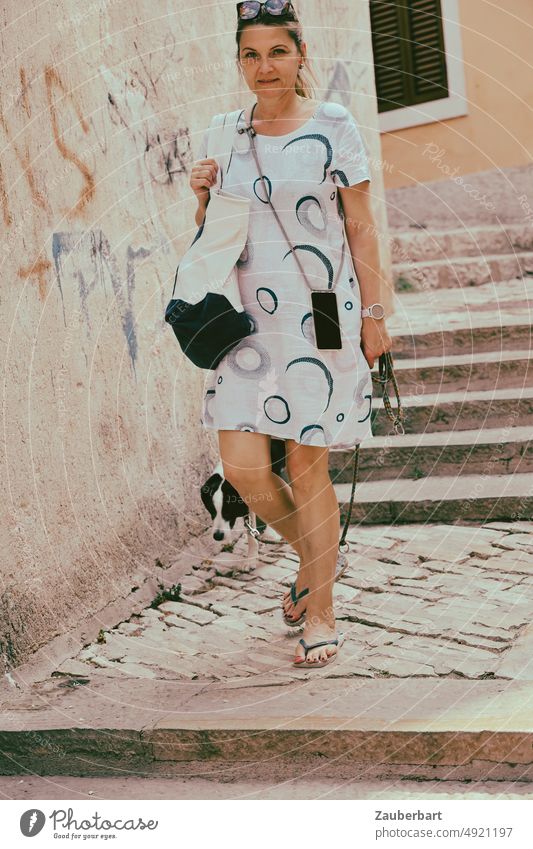 Frau im weißen Sommerkleid geht mit ihrem Hund eine Treppe hinunter Kleid Urlaub Spazierengehen Reisen Touristin freundlich Flipflops Ferien & Urlaub & Reisen