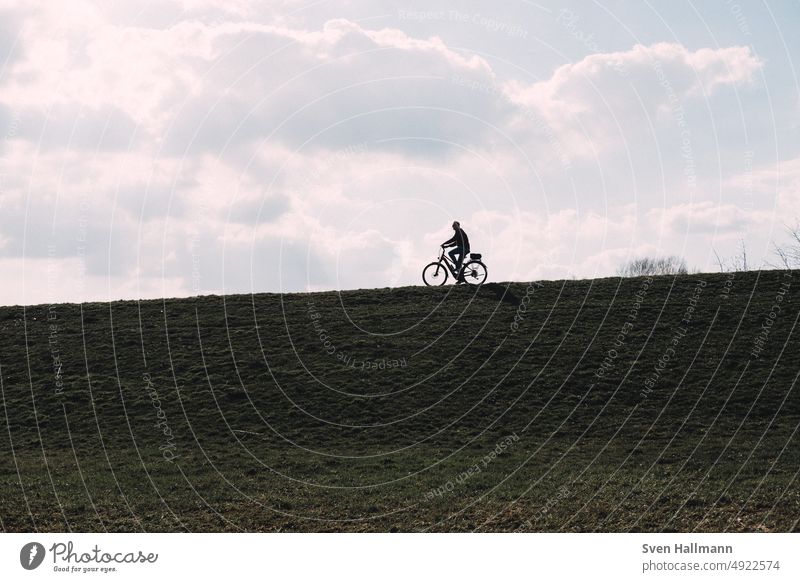 Radfahrer auf Deich radeln Wolken Himmel im Freien Fahrrad Fahrradfahren Schatten Silhouette Radfahren Lifestyle Bewegung Sport urban schnell Geschwindigkeit