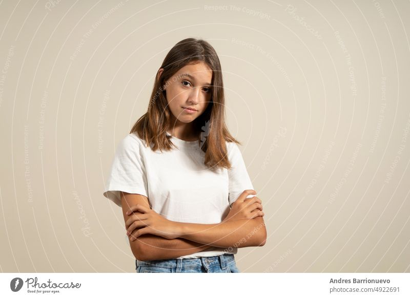 Porträt eines wütenden hispanischen Teenagers mit warnend verschränkten Armen, isoliert auf beigem Studiohintergrund. vereinzelt verärgert lässig Mädchen Frau
