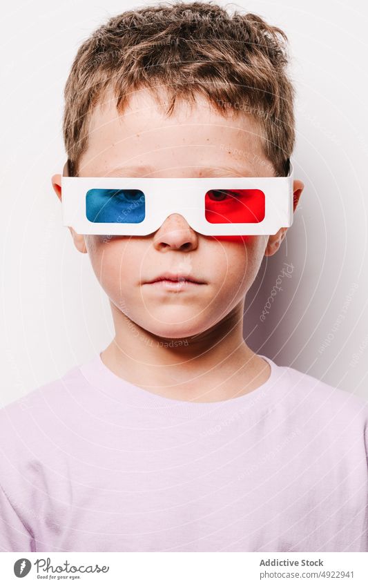 Gefühlsloser Junge mit bunter 3D-Brille 3d Kind unterhalten Sehvermögen Vergnügen Kindheit Hobby Karton lässig Atelier optisch bezaubernd Stil Vorschein süß