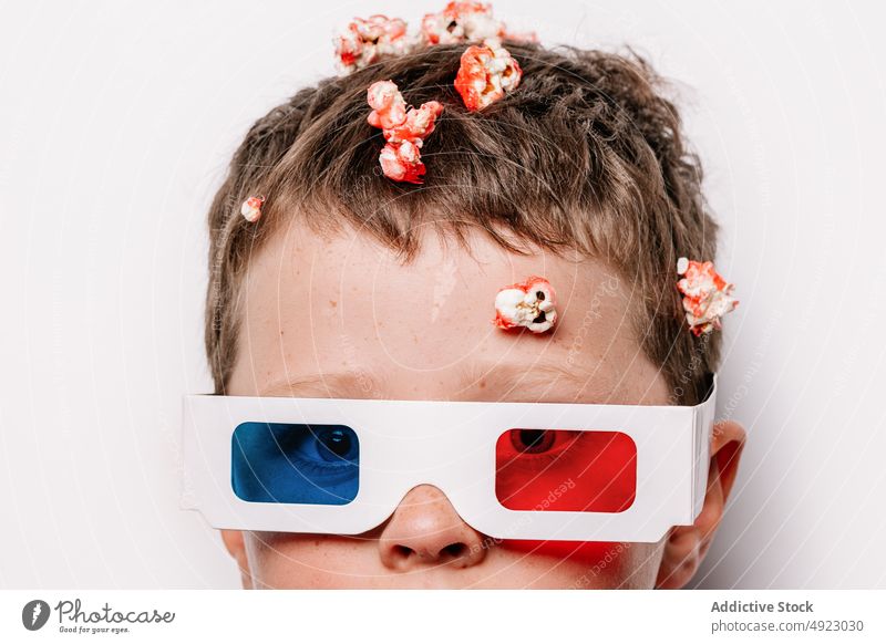 Junge mit 3D-Brille und Popcorn über dem Kopf im Studio Kind 3d Popkorn Snack werfen unordentlich Vergnügen süß appetitlich Spaß haben Geschmack Film Karikatur