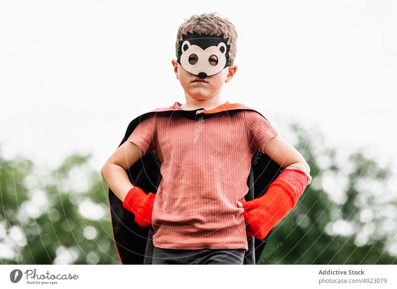 Superheld mit Igelmaske im Park Junge Mundschutz spielen Aufstieg Wochenende Tracht so tun, als ob knien Stein Klotz behüten Mut Kind Kap Hände an der Taille