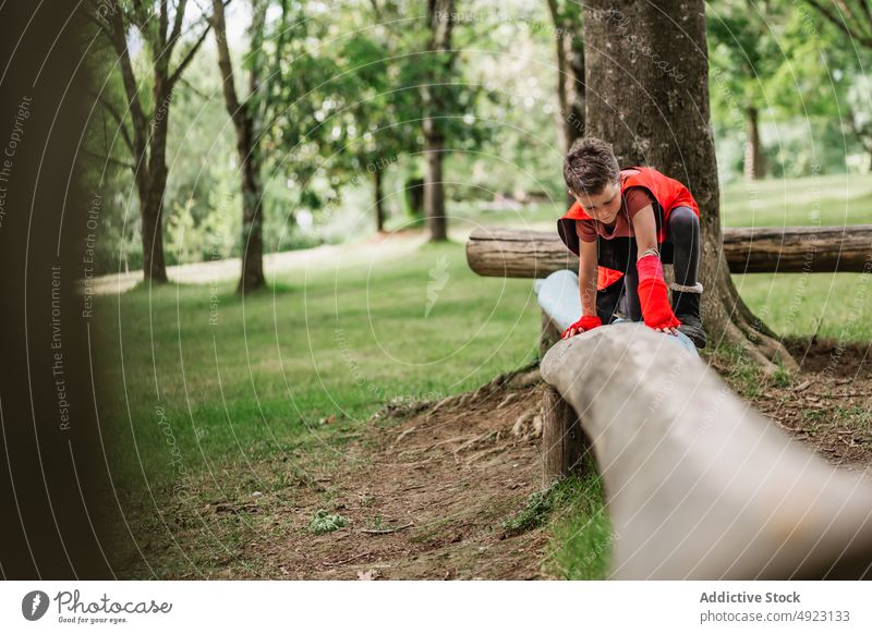 Junge im Superheldenkostüm balanciert auf Baumstamm Totholz Spaziergang Gleichgewicht Wald Wochenende Tracht männlich Sommer Park Kap spielen Kind bezaubernd