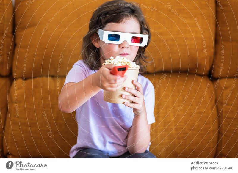Mädchen mit 3D-Brille und Popcorn im Kino Kind Fernbedienung Wandel & Veränderung 3d Film Showtime Popkorn Kanal Snack Regler Lebensmittel Kalorie Fernsehen