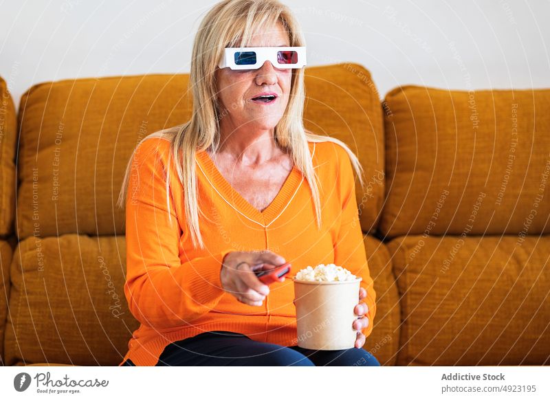 Frau mit 3D-Brille isst Popcorn 3d Film zuschauen essen Popkorn heimwärts Showtime Kanal Regler Snack Fernsehen abgelegen unterhalten Lebensmittel Kalorie