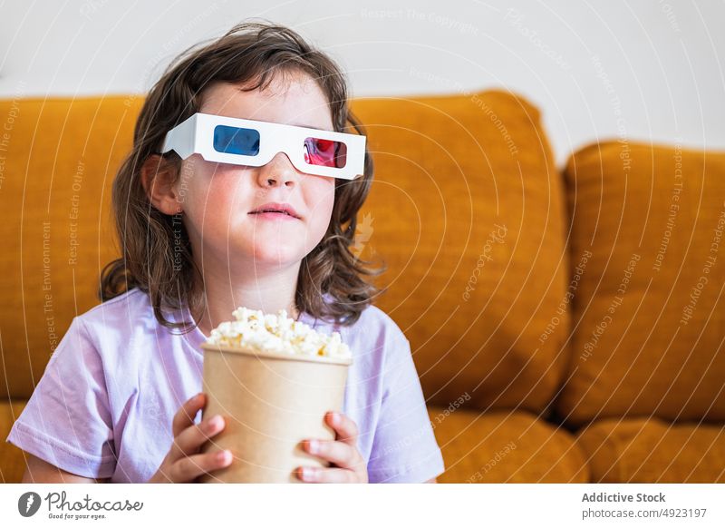 Mädchen mit 3D-Brille und Popcorn im Kino Kind Fernbedienung Wandel & Veränderung 3d Film Showtime Popkorn Kanal Snack Regler Eimer Lebensmittel Kalorie