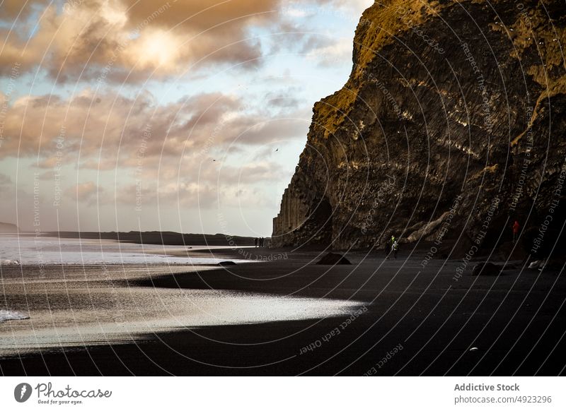 Reisende bewundern die vulkanische Landschaft mit schwarzem Sandstrand Strand Formation Zusammensein MEER Natur winken Unwetter Stein Klippe Menschen Küste Meer