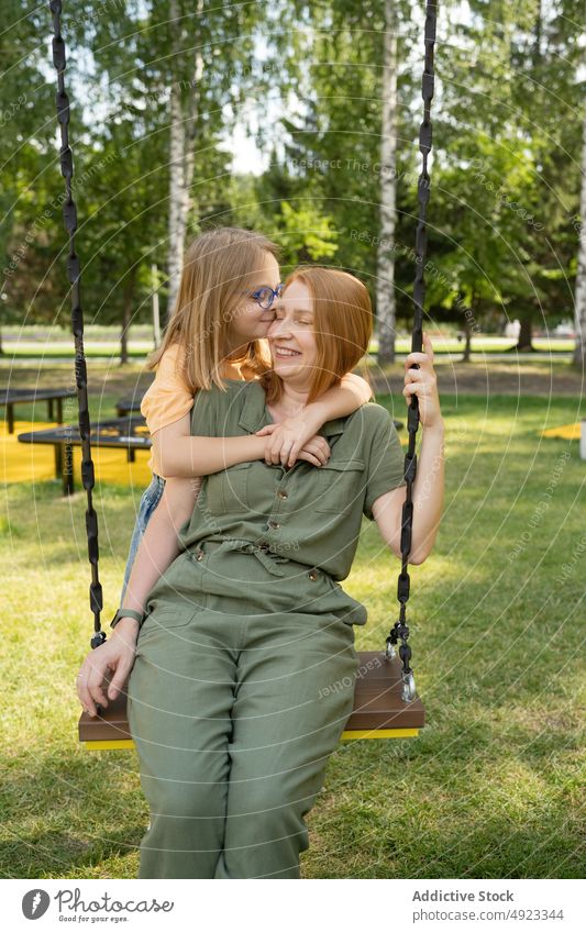 Tochter umarmt Mutter auf Schaukel pendeln Park Umarmung Liebe Zeitvertreib Bonden Mutterschaft Zeit verbringen Umarmen Inhalt Mädchen Kind Eltern Zusammensein