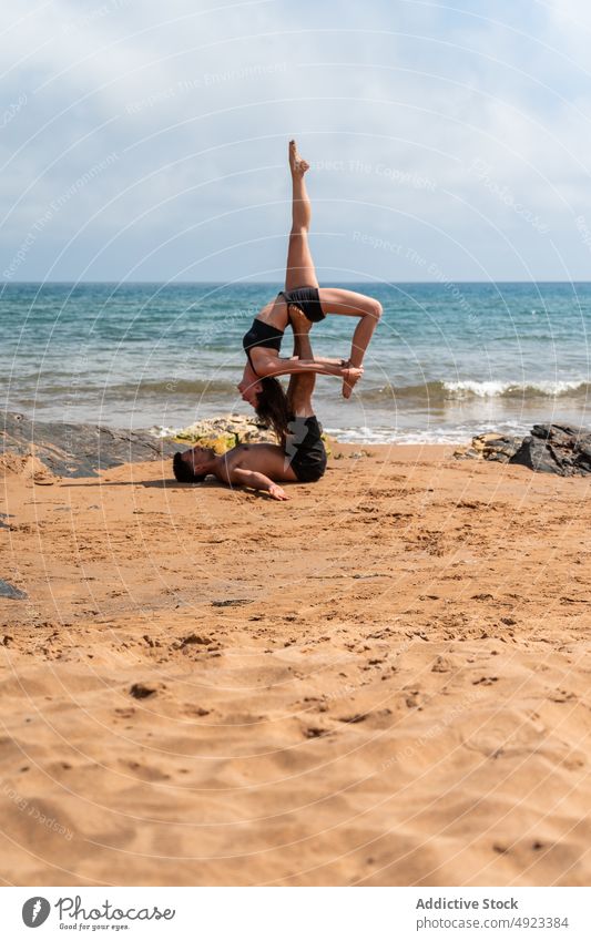Paar beim Acro-Yoga am Meer Akro-Yoga Strand Zusammensein Dehnung MEER Gleichgewicht Sommer üben Asana Mann Frau Energie Sitzung Wohlbefinden Sportbekleidung