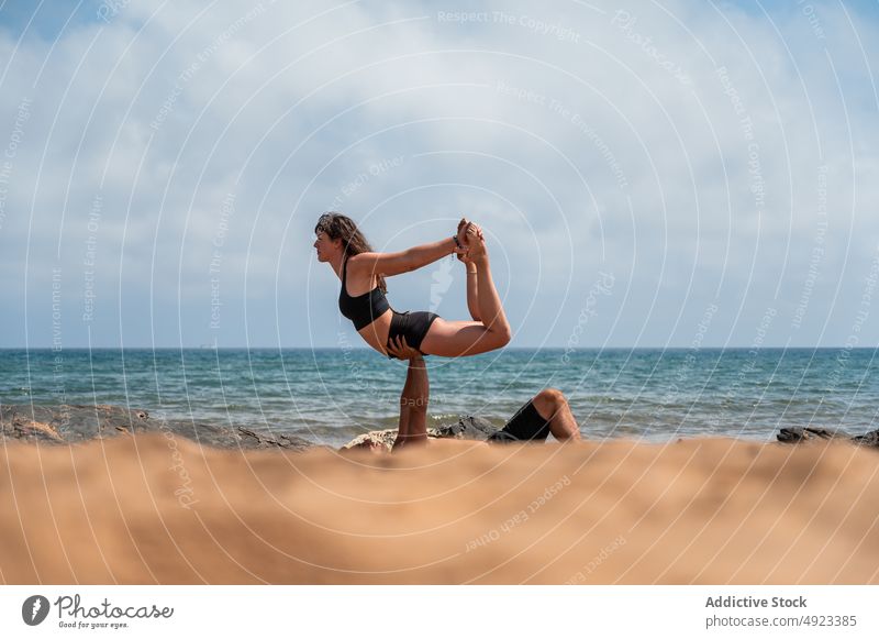 Mann und Frau machen Akro-Yoga in der Nähe von Meereswellen Paar Strand Gleichgewicht Zusammensein MEER Sommer üben Ufer Asana Freundin Seeküste Energie Sitzung