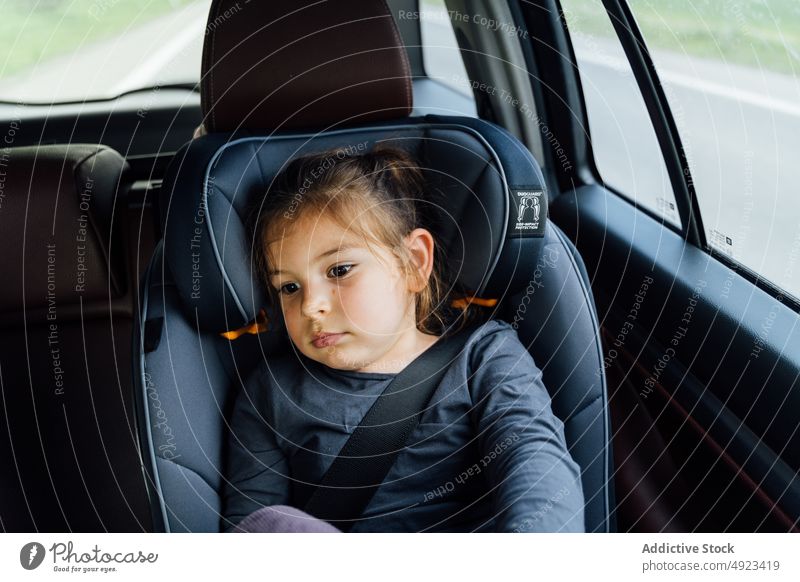 Entzückendes ruhiges Kind, das sich während der Fahrt im Auto ausruht ruhen PKW müde Autoreise Automobil reisen Passagier Mädchen Autositz Verkehr befestigen