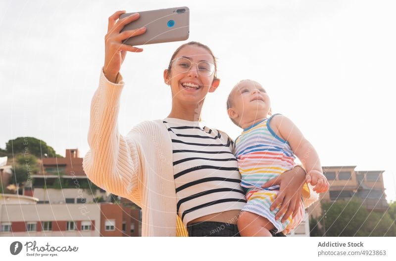 Junge Mutter nimmt Selfie mit Sohn auf der Straße Smartphone Lächeln führen Glück Wochenende Zusammensein Frau jung Liebe Haus heiter Gerät Mobile Telefon Mama