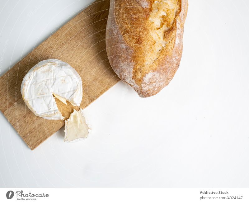 Camembert-Käse und Brot auf dem Schneidebrett lecker hölzern frisch Feinschmecker Spielfigur organisch appetitlich Küche schmackhaft natürlich köstlich Brotlaib