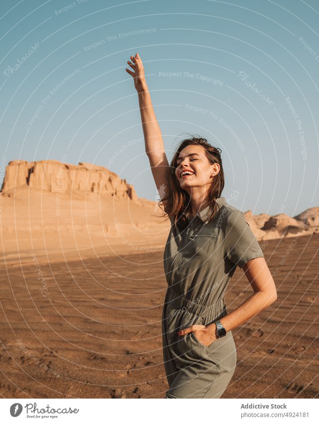 Glückliche Frau in der Wüste stehend wüst Natur Ausflug reisen Abenteuer Reise Tourist Felsen genießen Zeitvertreib Arm angehoben Augen geschlossen heiter
