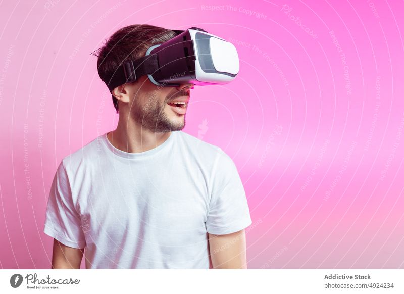 Fröhlicher Mann mit VR-Brille, der seinen Erfolg feiert Virtuelle Realität Cyberspace futuristisch Hochtechnologie Sieg gewinnen feiern Spieler modern erreichen