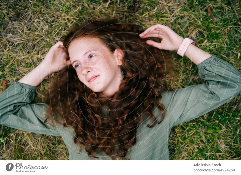 Ruhige sommersprossige Frau, die sich auf einer Wiese entspannt und wegschaut Lügen Rotschopf Lächeln Windstille sich[Akk] entspannen Gras Natur verträumt