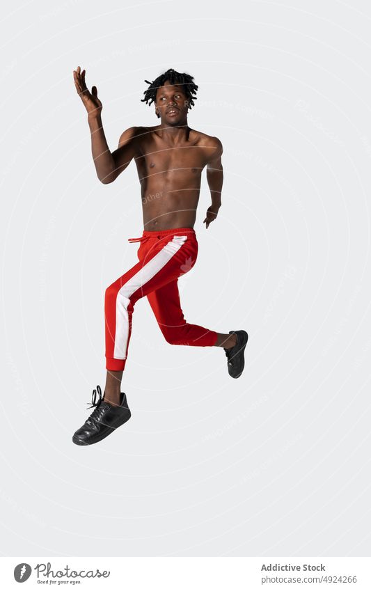 Schwarzer Sportler ohne Hemd springt auf springen Energie Training Kraft in der Luft Übung Aktivität Stärke männlich jung schwarz Afroamerikaner ethnisch