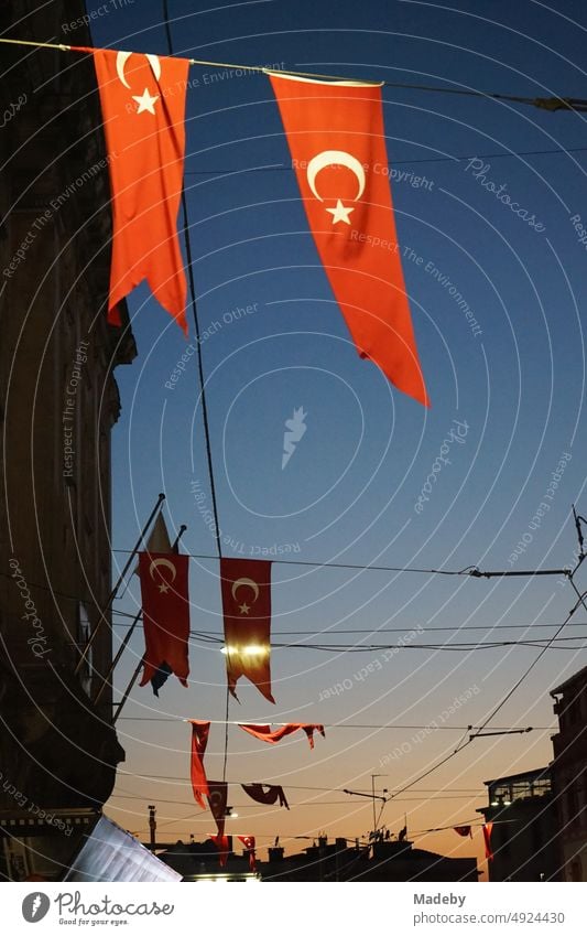 Rote türkischen Fahnen bei Nacht im Licht der Straßenbeleuchtung am Galataviertel in der Istiklal Caddesi im Stadtteil Beyoglu in Istanbul am Bosporus in der Türkei