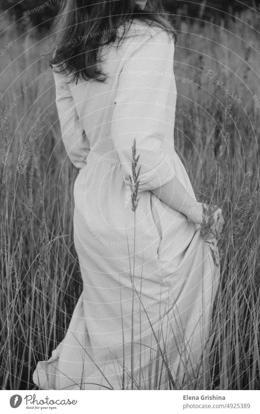 Eine junge Frau in einem Leinenkleid geht durch eine Wiese. Mädchen Behaarung Blumen Feld Sommer geschlossene Augen Porträt Ruhe Lifestyle Verlangsamung brünett