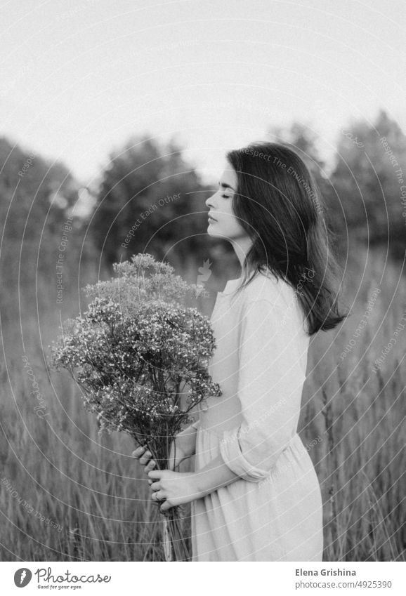 Porträt einer jungen Frau. Das Mädchen hält einen Strauß mit Wildblumen in den Händen. Kleid geschlossene Augen Leinenkleid Stille Einsamkeit