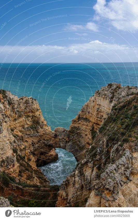 Wunderschöne Klippenformation an der Küste des Ozeans in verschiedenen Blautönen Algarve atlantisch Hintergründe blau blaue Farbe Wolken Textfreiraum Tag