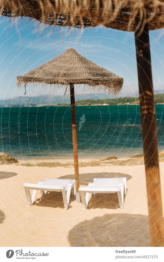Liegestühle mit Strohsonnenschirmen am Meer Strand Textfreiraum Spanien paradiesisch Liegestuhl Sonnenschirm Karibik MEER atlantisch Küste Wasserseite genießen