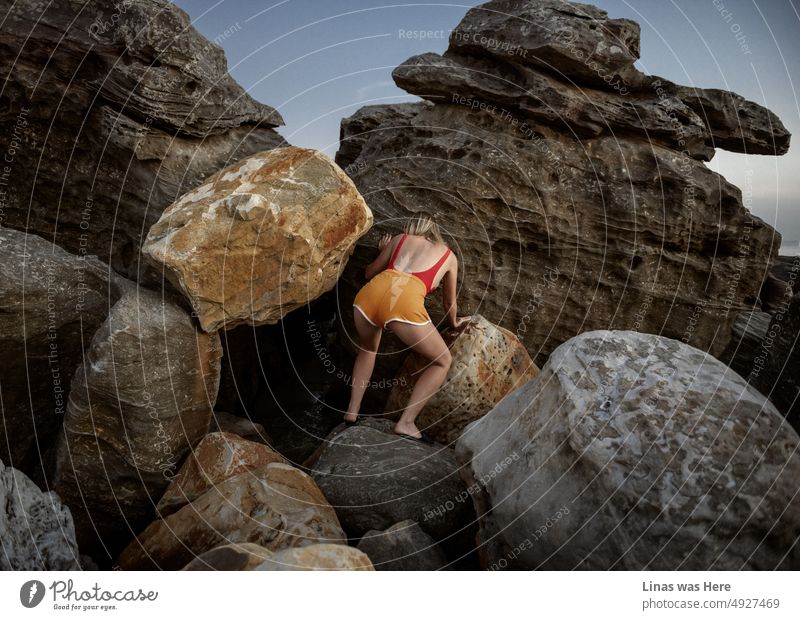 Einige riesige Felsen sind perfekt für ein wunderschönes blondes Mädchen zum Klettern. Bei einem Urlaub in Vietnam, Phu Quoc Island. In ihren gelben Shorts und dem roten Badeanzug kann man ihre sexy Kurven und Muskeln sehen. Aber es geht hier nicht um Sport.