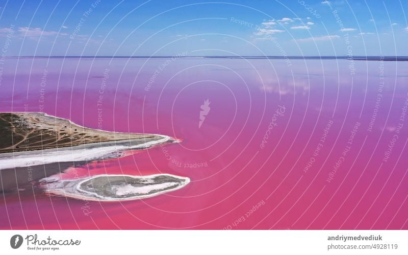 Luftaufnahme von White Salz an den Ufern der Insel in Pink Island und blauer Himmel . Lemuria-See, Ukraine. See wird natürlich rosa aufgrund von Salzen und kleinen Krebstieren Artemia im Wasser