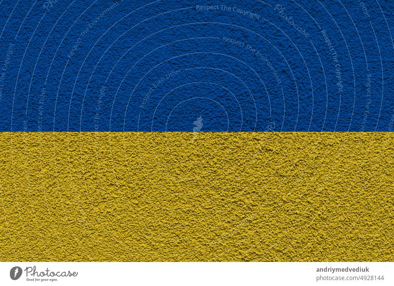 Ukrainischen Staat Nationalflagge. Textur Beton Grunge Wand in gelb-blaue Farbe. Staatssymbol der Ukraine und Ukrainer. Ukrainische Flagge auf einer Betonwand Hintergrund.