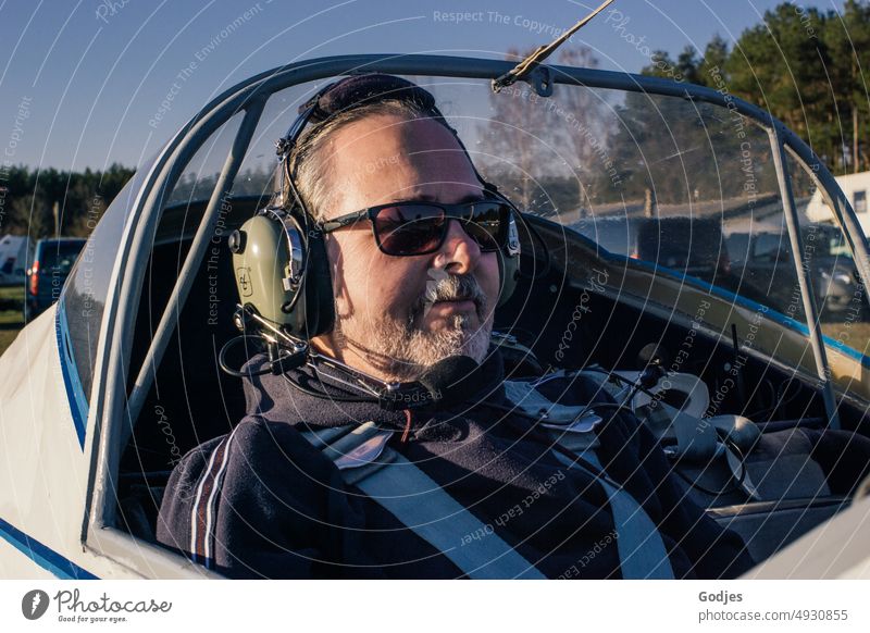 Mann sitzt in Flugzeug mit Headset auf dem Kopf Fliegen Sportflugzeug Luftverkehr fliegen Portrait Flugzeugstart Ferien & Urlaub & Reisen Flugzeuglandung Himmel