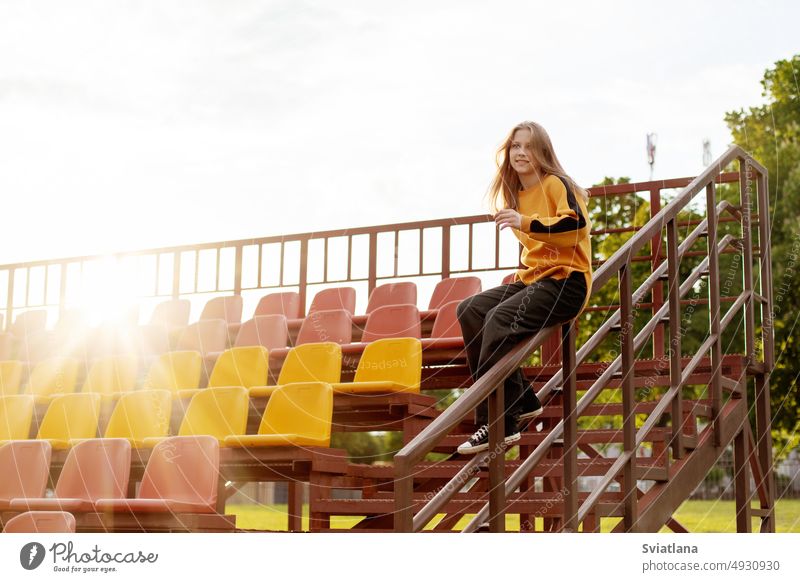 Ein junges Mädchen hat Spaß und rutscht das Geländer im Stadion hinunter Reling Treppe Mitfahrgelegenheit schön cool Sliden spielen Teenager Treppenhaus