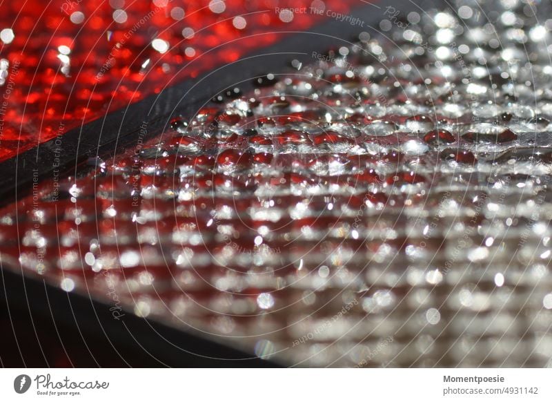 Tropfen auf weißem und roten Untergrund Plastik Wasser Wassertropfen nass Nahaufnahme Regen Makroaufnahme feucht Reflexion & Spiegelung Farbfoto Detailaufnahme