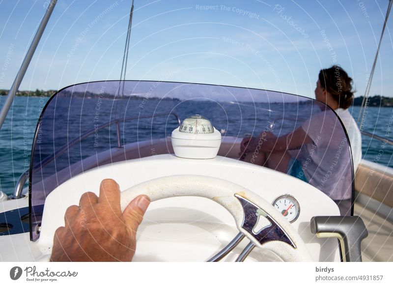 Fahrt in einem Motorboot auf einem See. Cockpit mit Kompass und Lenkrad Wasserfahrzeug Bootsfahrt Führerstand Hand Frau Sportboot Ferien & Urlaub & Reisen