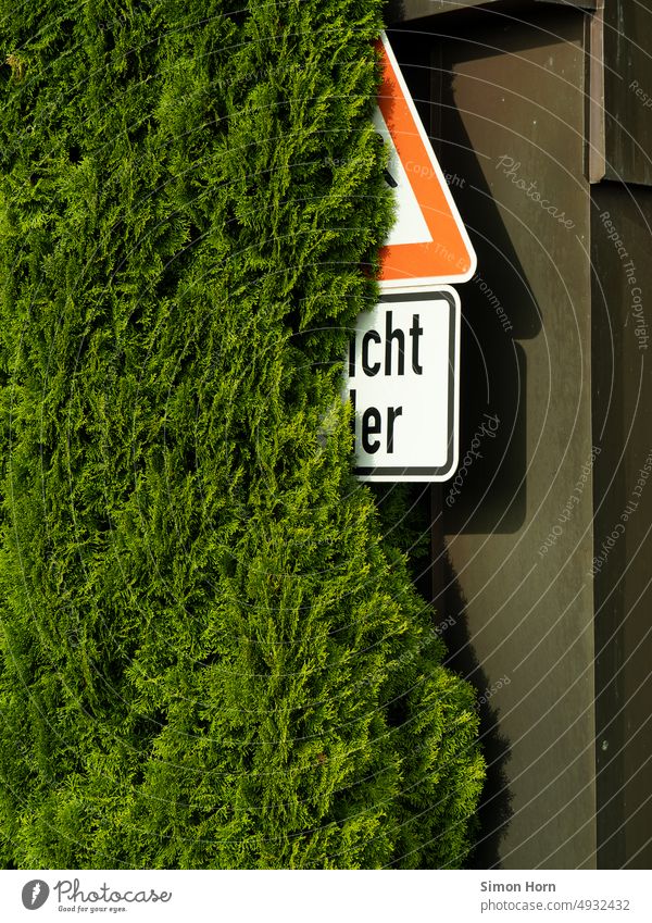 Straßenschild hinter Hecke Warnhinweis Strassenschild Schilder & Markierungen Busch versteckt Vorsicht entziffern Zeichen Symbole & Metaphern Hinweisschild