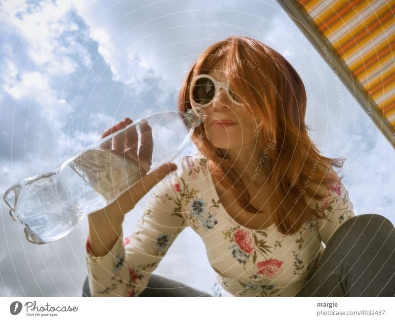 Eine Frau mit Sonnenbrille schmeckt Wasser aus einer Wasserflasche Durst durstig Getränk Erfrischungsgetränk Durstlöscher Farbfoto Trinkwasser Flüssigkeit
