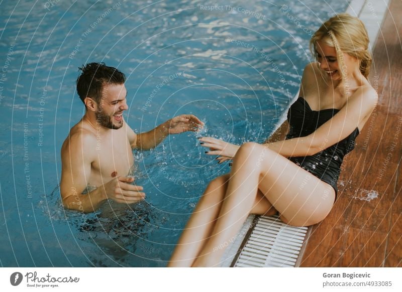 Junges Paar entspannt sich am Rande des Innenpools Frau Lächeln Mann Wasser jung Glück Wellness im Innenbereich Erwachsener Kaukasier genießen Bikini Badeanzug