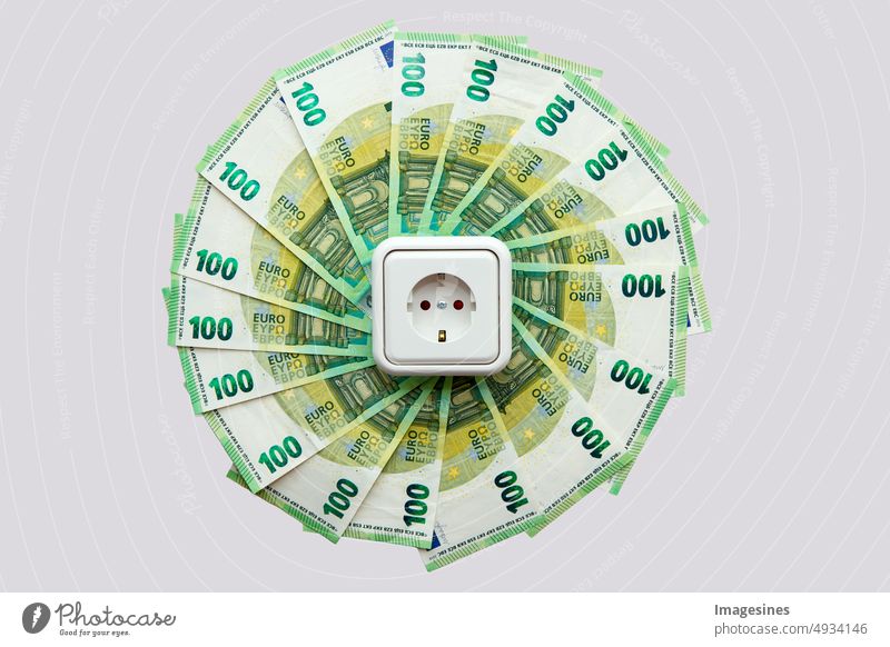 Steckdose und Euroscheine im Kreisform gelegt. Konzept des Stromsparens zu Hause. Euro-Banknoten. Stromkosten und teures Energiekonzept gefächert teuer energie